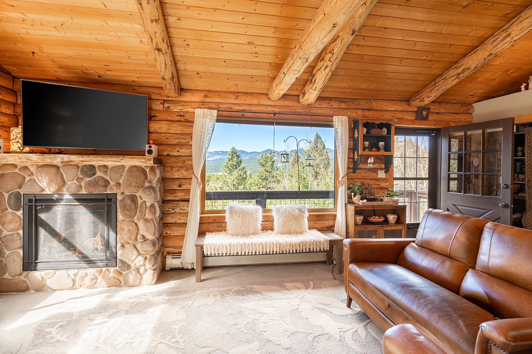 Cabin living room with leather sofa and mountain views