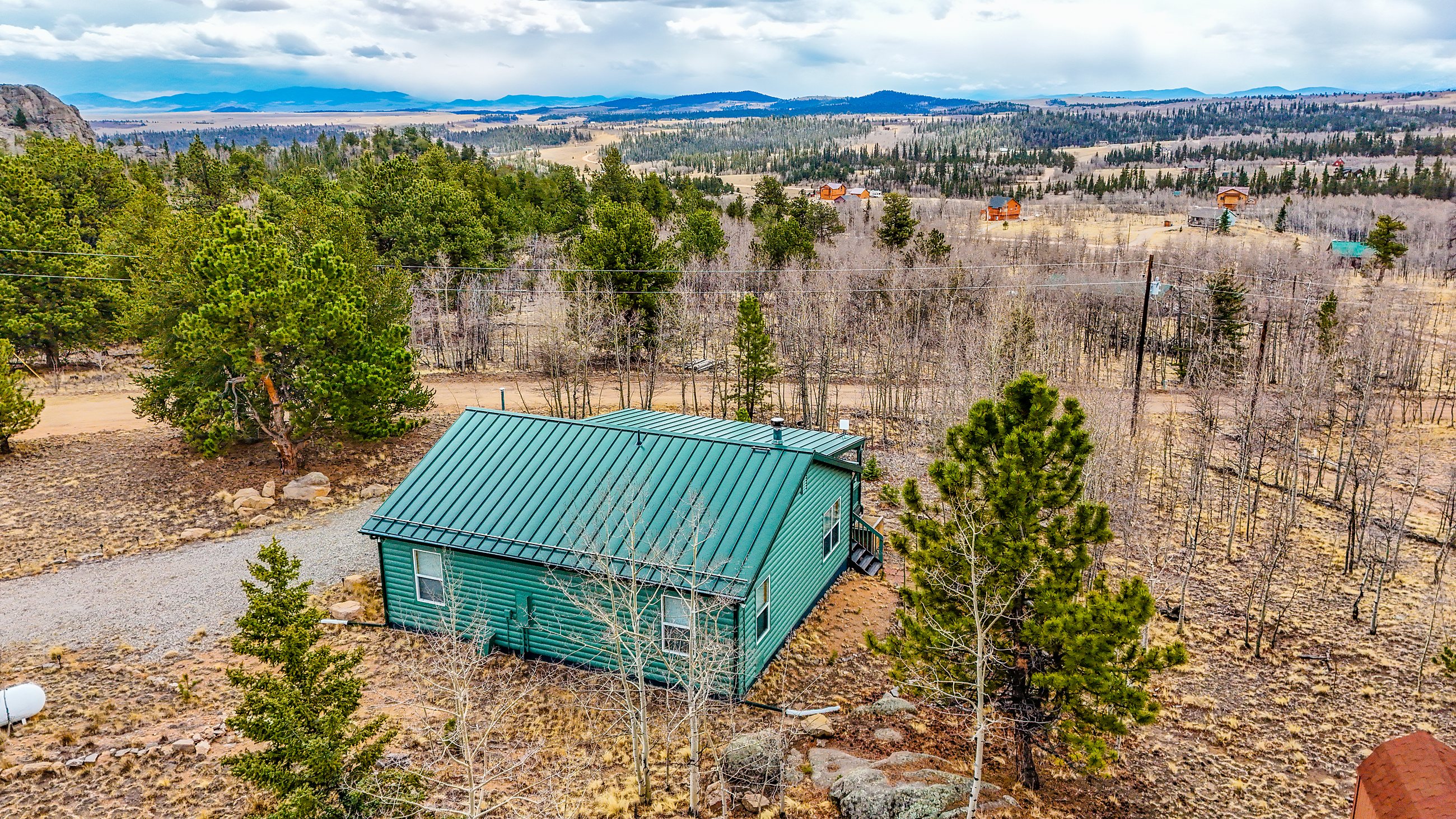 Aerial drone view of a cabin property in the evergreens